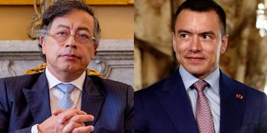 Two men in formal suits posing indoors with serious expressions.