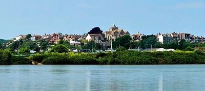 A scenic view of a town with historic buildings across a calm river.