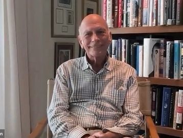 Marc Goldman sitting in a chair in front of a bookshelf