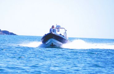 Image: a head on view of a fast RIB boat in Falmouth Bay, UK