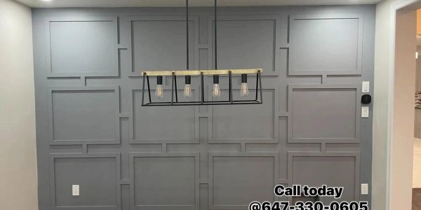 Gray paneled wall with overhead light fixture.