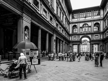 Crowd at a historic architectural site with an artist stall.