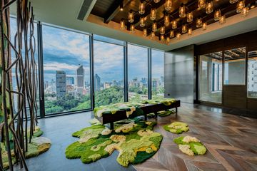 Modern room with large windows and green moss-like carpet.