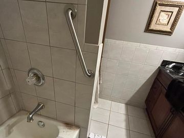 Bathroom corner with bathtub and sink.