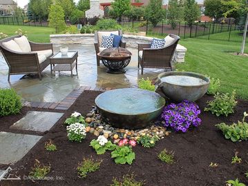 Backyard seating area with water feature and fire pit.