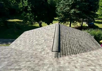 View of a roof with grey shingles.