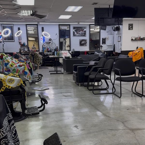 Interior of a modern barbershop with chairs and mirrors.