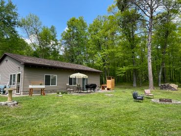 A house with a spacious lawn and trees.