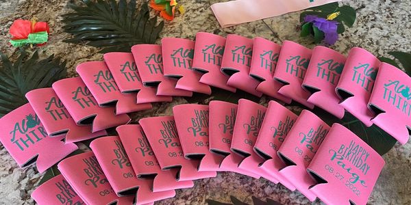 Pink drink koozies for a tropical-themed birthday party with floral decorations for a rental party setup in Port Aransas.
