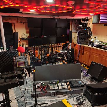 A music studio setup with guitars, keyboards, and audio gear.