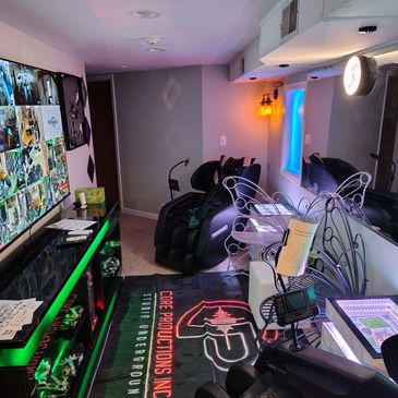 Gaming or streaming room with multiple screens and neon lights.