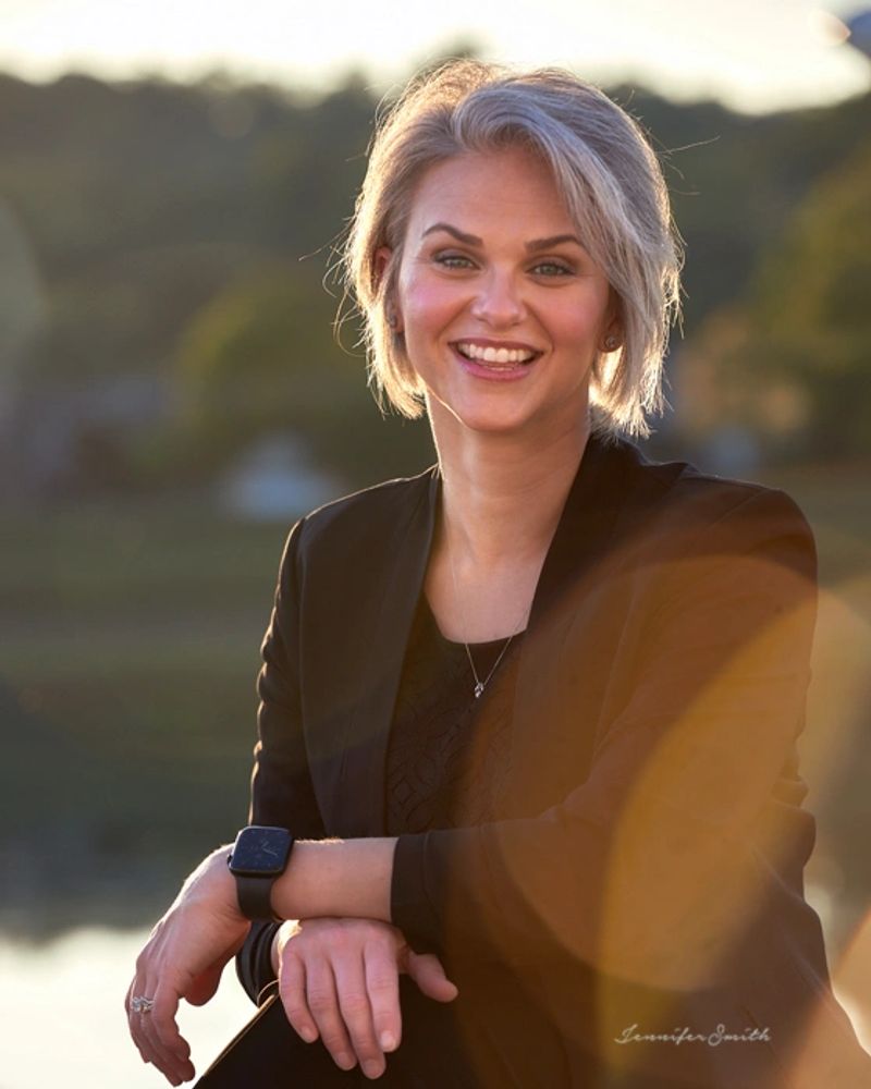 Nurse coach in professional wear sitting on bench smiling at viewer