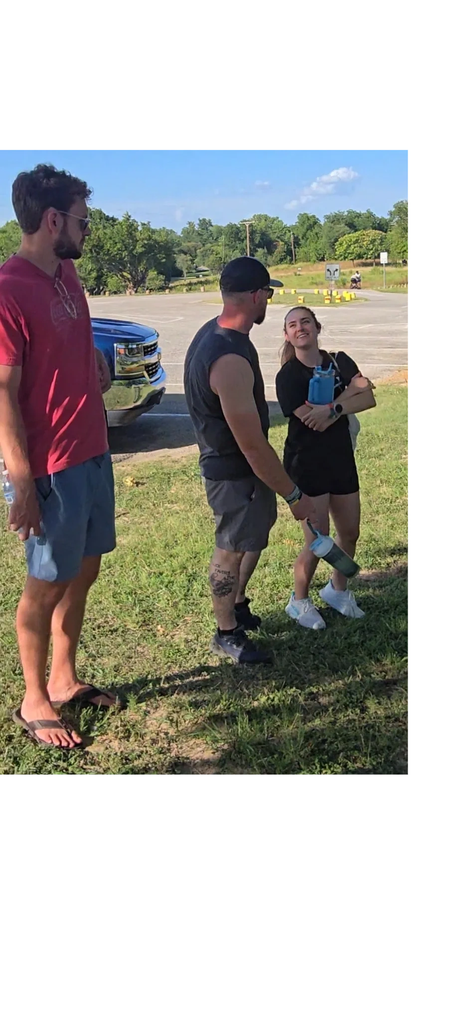 Three people chatting outdoors on a sunny day.