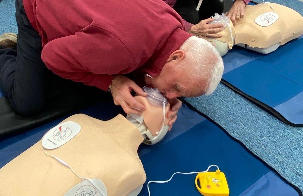 Student practising rescue breaths on a training manikin with a pocket mask during a First Aid for Di
