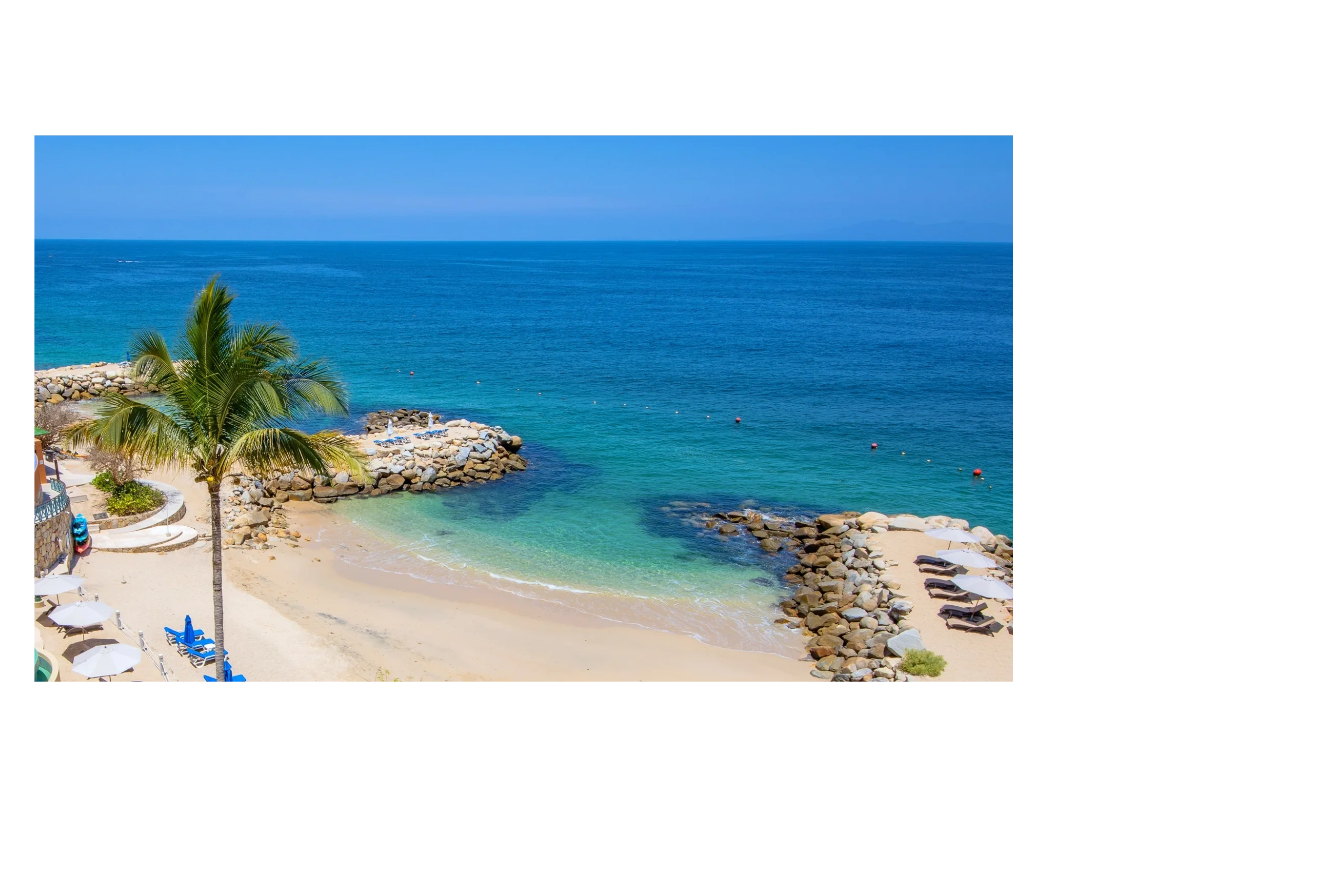 Sunny beach with palm trees, lounge chairs, and clear blue ocean, perfect for snorkeling, paddleboarding or kayaking.