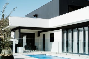 Modern house with a swimming pool and glass railing.