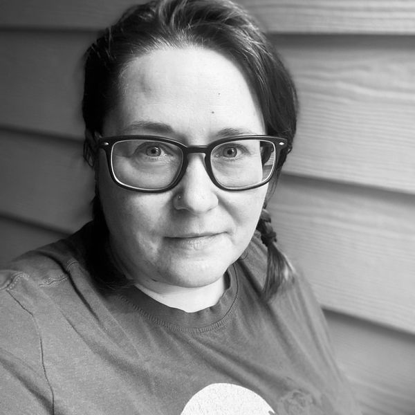 a black and white photo of a woman, the owner of the shop. She has two short braids in her hair and 