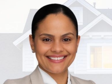 Smiling professional woman in front of a house background.