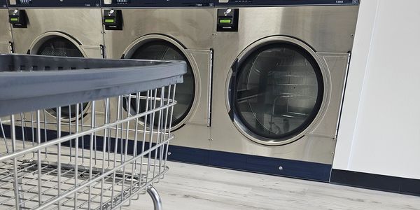 Laundry cart with large dryers in a laundromat.