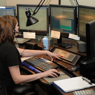 A woman working on a computer with multiple screens