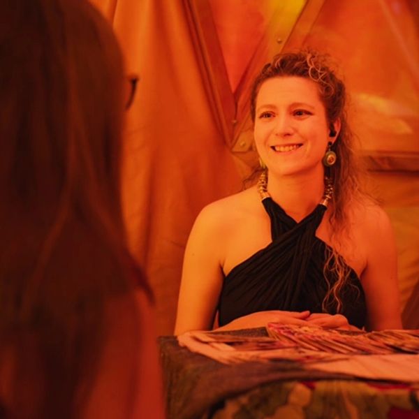 Tarot reader smiling while giving tarot reading to person