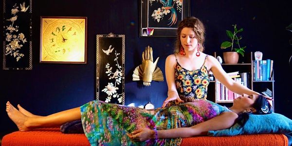 Reiki Master performing in-person healing session to woman 