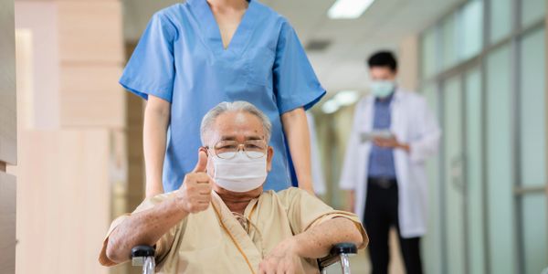 A senior man giving a thumbs up