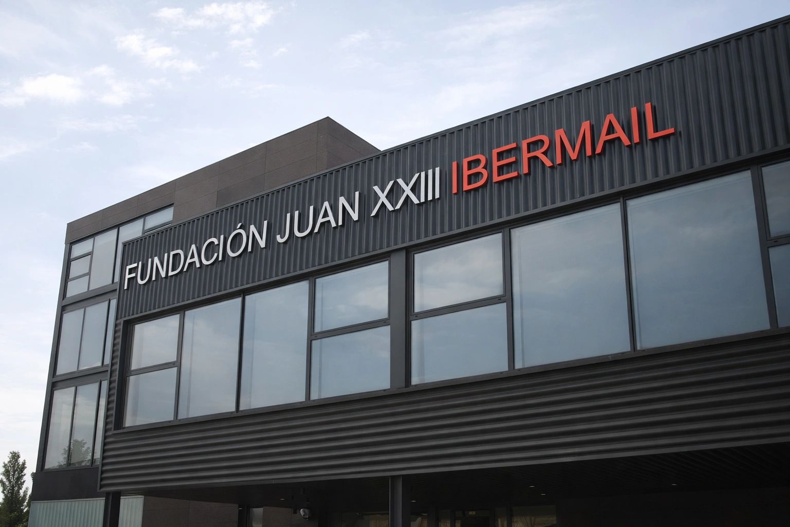 Montaje de rótulo en altura en fachada de edificio corporativo en Madrid.