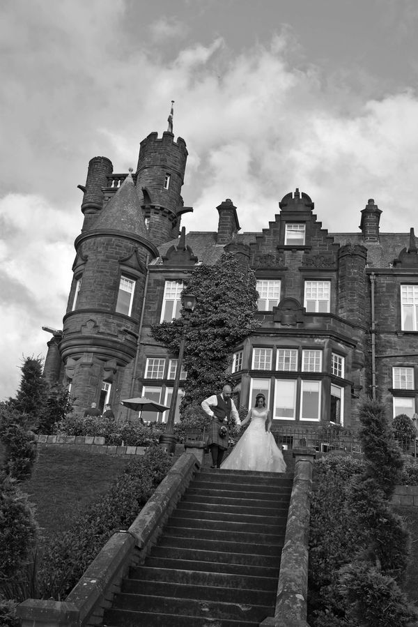 Bride and groom on steps with the Sherbrook Castle Hotel in the background