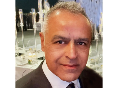 Man in formal suit and tie at an event.
