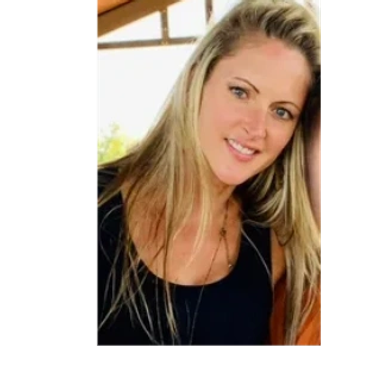 Smiling blonde woman with blue eyes indoors.