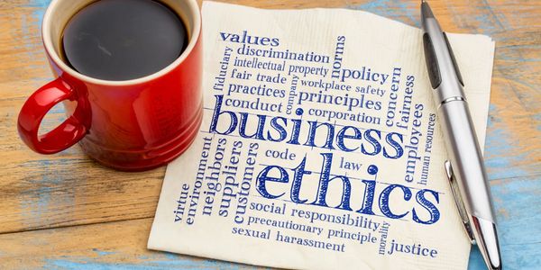 A cup of coffee next to a transcript about business ethics 