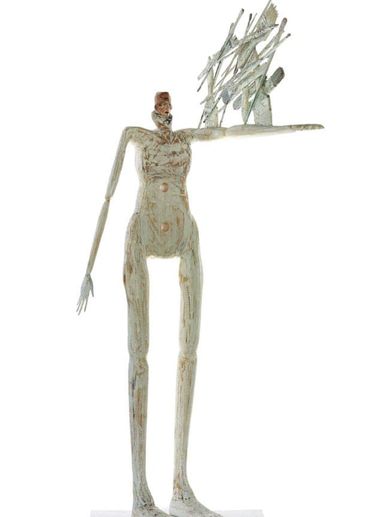 Tall abstract sculpture of a humanoid figure holding an intricate object.
