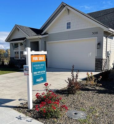 Modern house with a for sale sign in front yard.