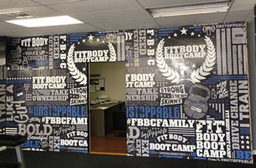 Wall covered with motivational fitness quotes at a gym entrance.