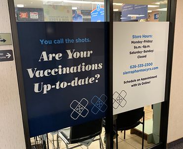 Sign asking if vaccinations are up-to-date at a pharmacy.