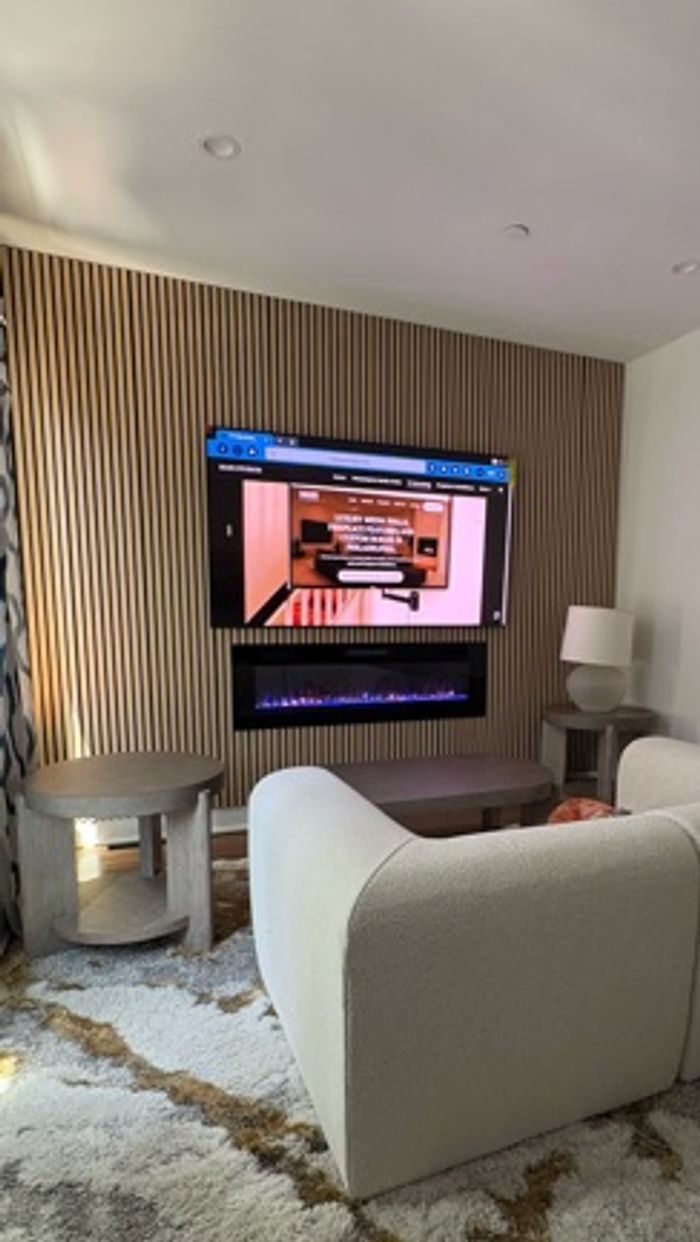 Custom media wall with TV, electric fireplace and wood slat panels installed by MASS Studios in Phil