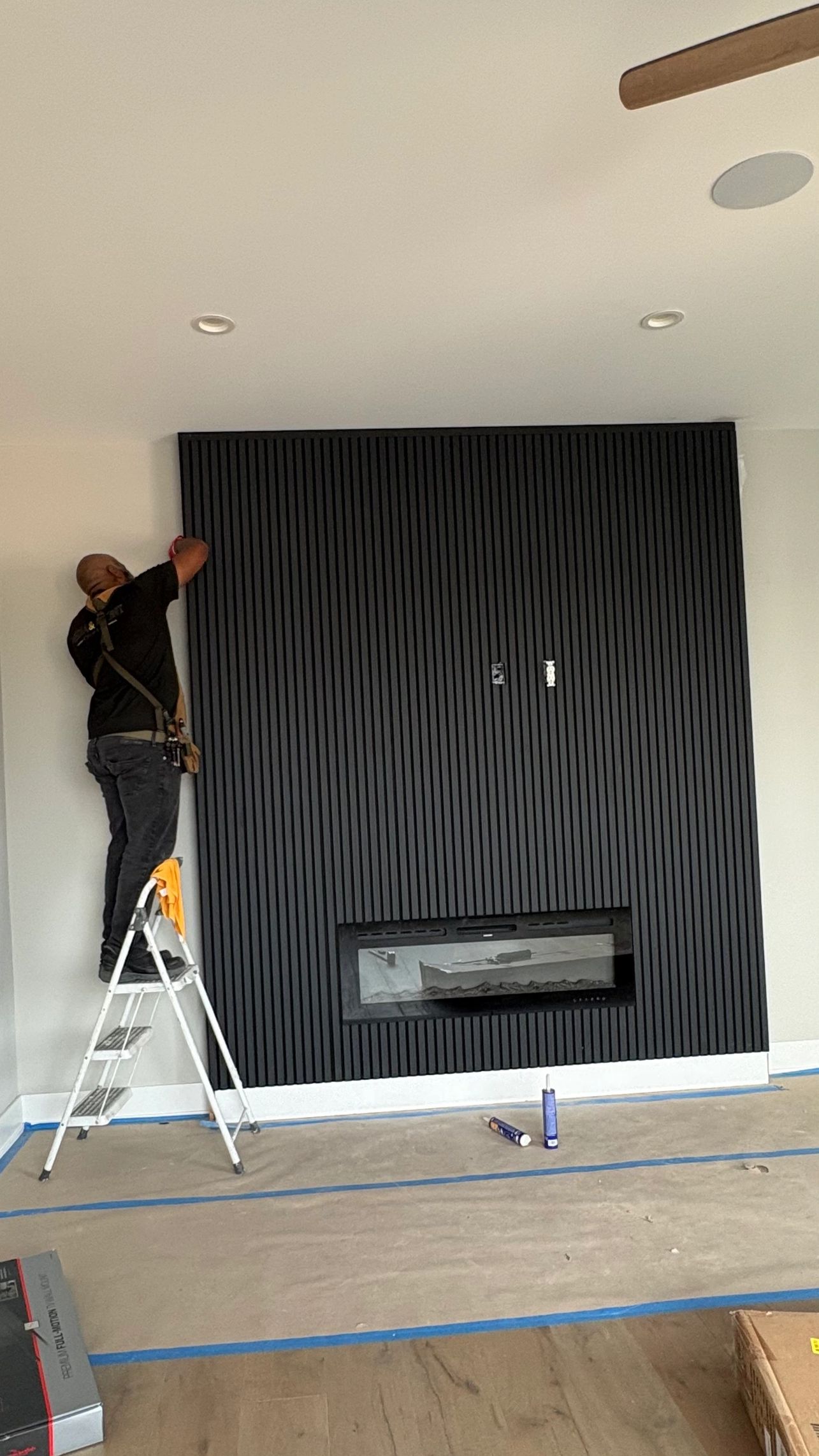 MASS Studios installer building a custom black slat media wall in Center City Philadelphia.