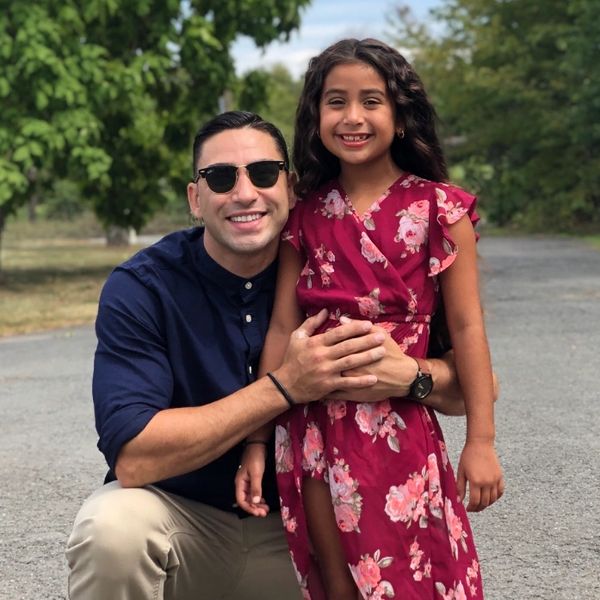 Father and daughter posing together for a picture in the summer 