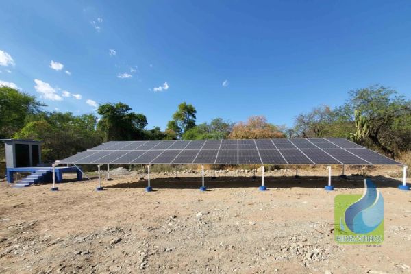 Paneles solares instalados en terreno abierto bajo cielo despejado.