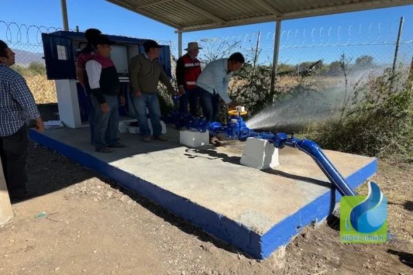 Hombres probando una bomba de agua en una estación al aire libre.