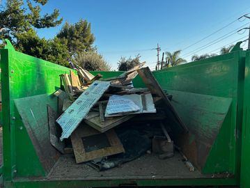 Yard debris removal service with green waste being collected.