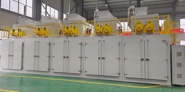 Large industrial drying oven with yellow safety railings inside a factory.