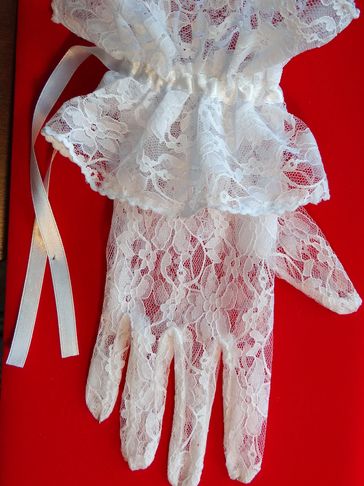 A White Lace Glove on a Red Color Background