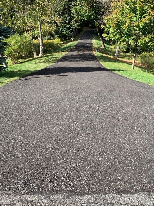 Long residential private road with freshly laid recycle asphalt material.