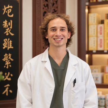 Smiling male doctor in white coat indoors.
