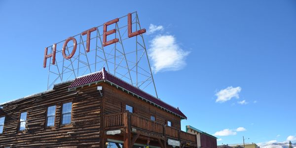 Rustic wooden hotel building under a clear blue sky.