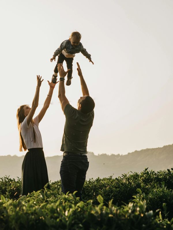 Parents lifting child up in the air