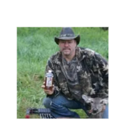 Man in camouflage holding a beverage outdoors.