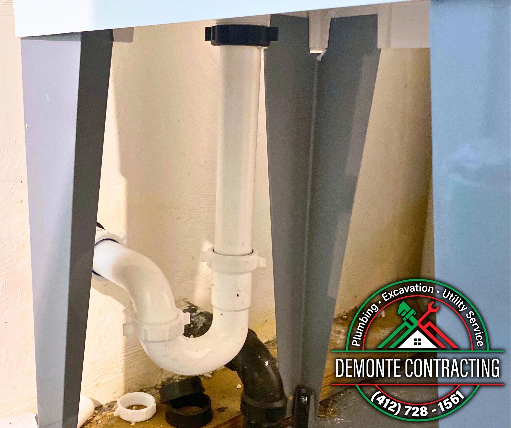 A professional plumber from a local Penn Hills, PA plumbing service under-sink drain.